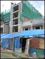 The workers huts in front of the Luxurious New Hotel